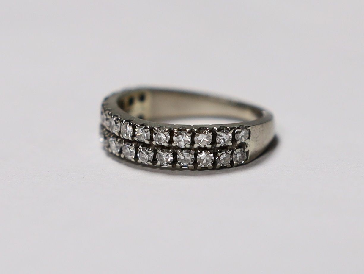 A white metal and two row round cut diamond set half eternity ring, size M, gross weight 3.9 grams.